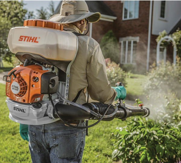 Professional pest control technician applying organic mosquito and tick prevention treatment
